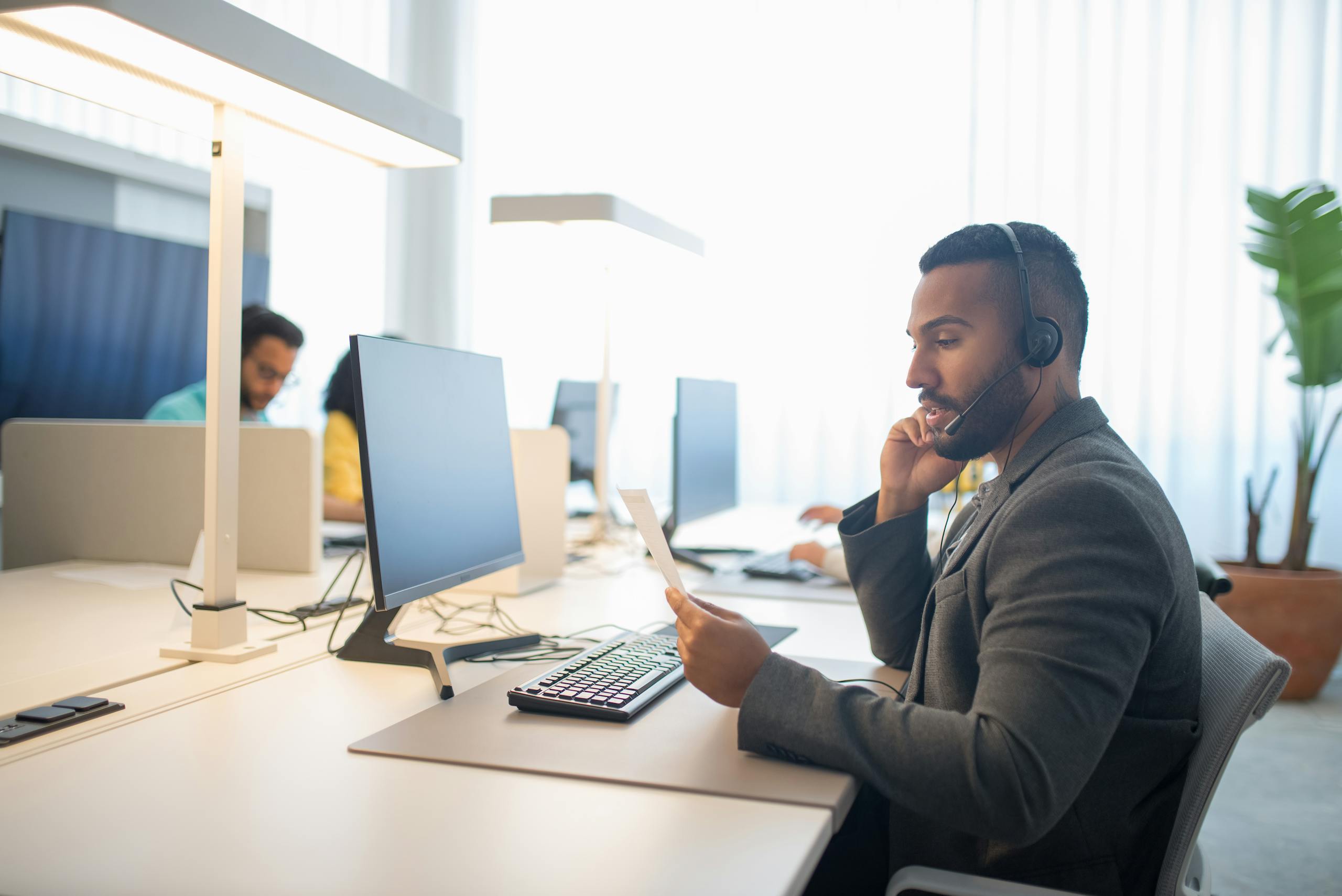 Modern office scene with professionals working collaboratively at desks with computers.